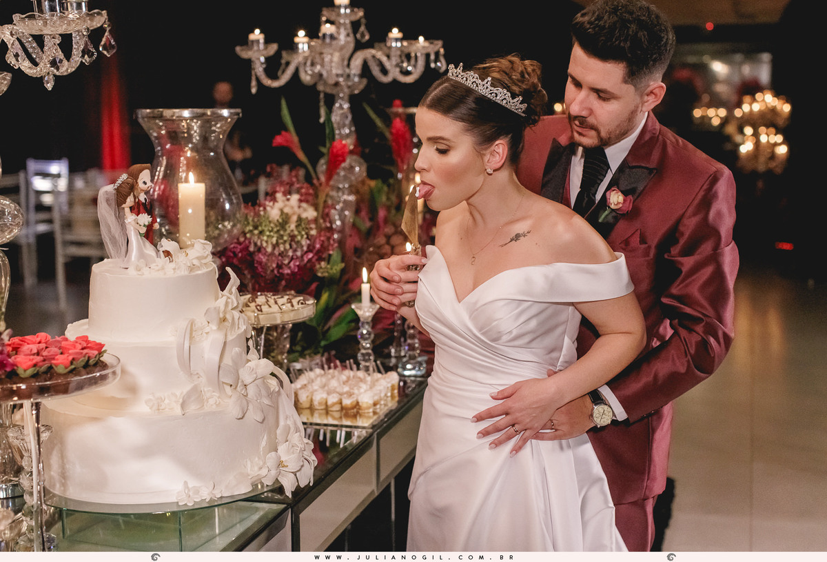 noivos em frente a mesa de doces e bolo na recepção de casamento no espaço santo fole