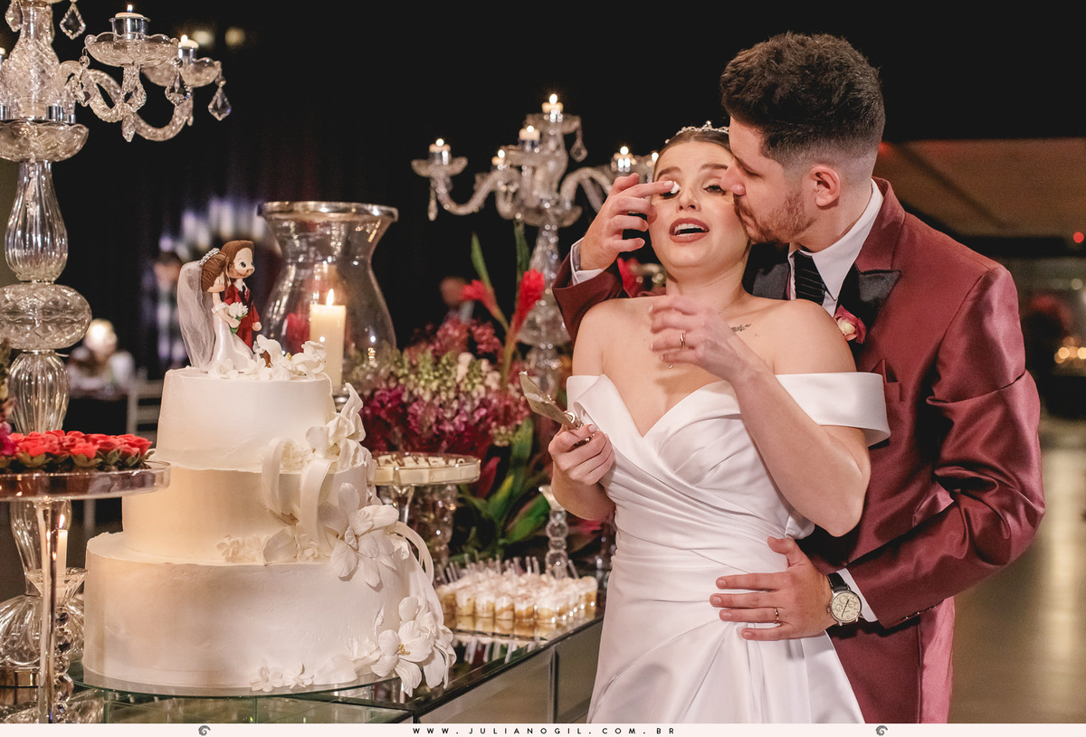 noivos em frente a mesa de doces e bolo na recepção de casamento no espaço santo fole