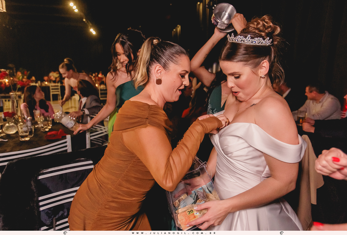 convidada colocando dinheiro no vestido da noiva