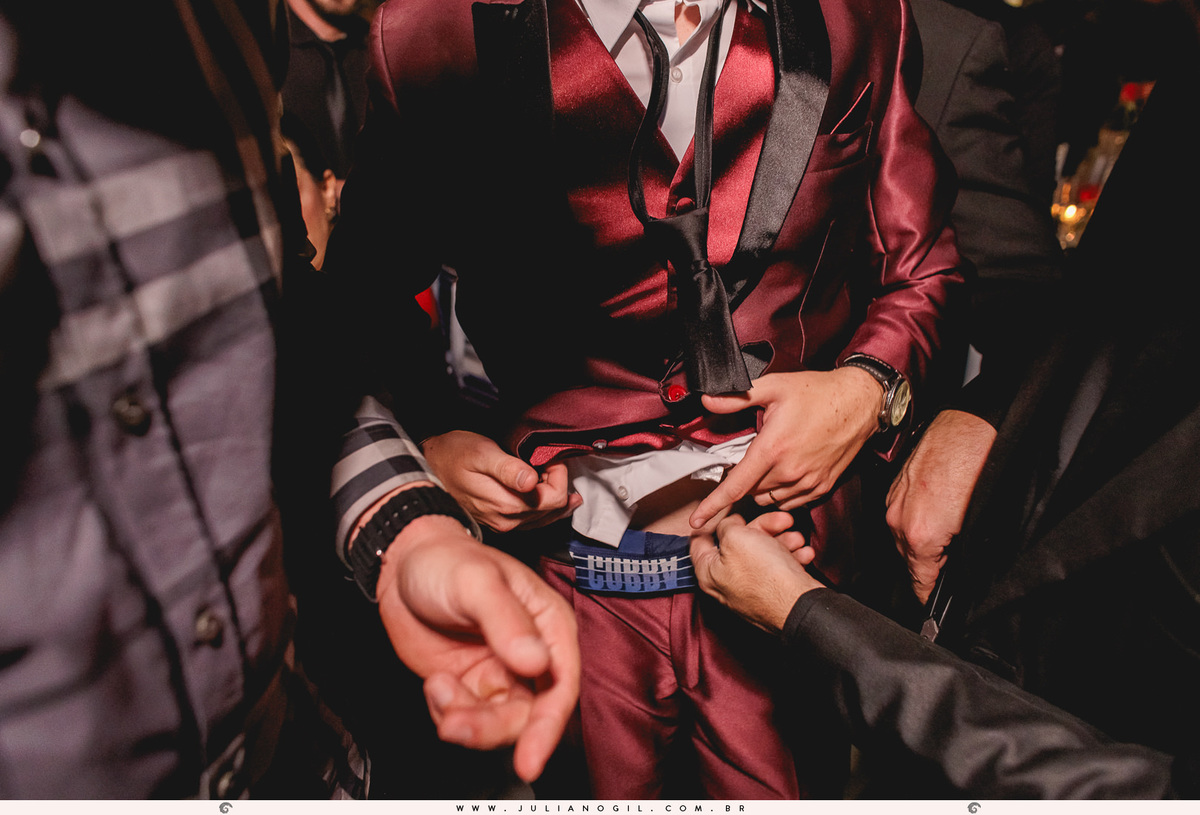 padrinhos tentando cortar a cueca do noivo