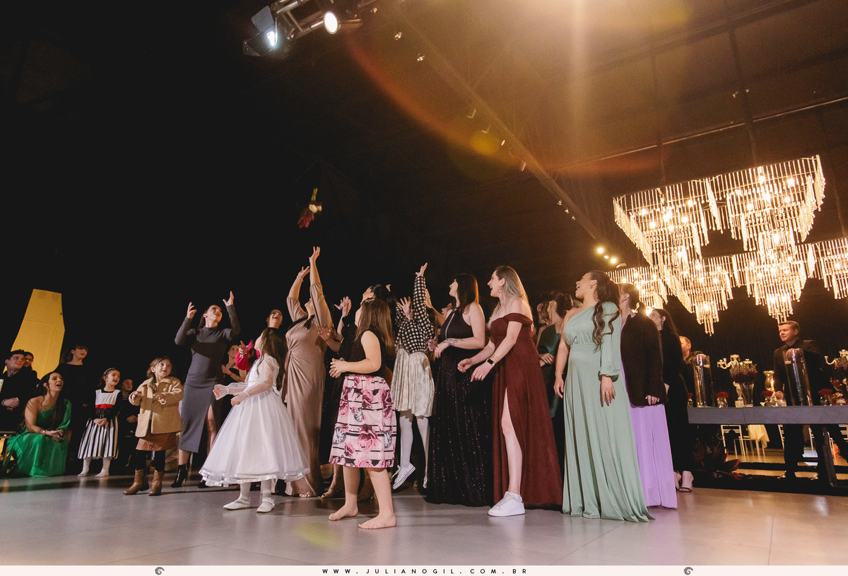 mulheres tentando pegar o buquê