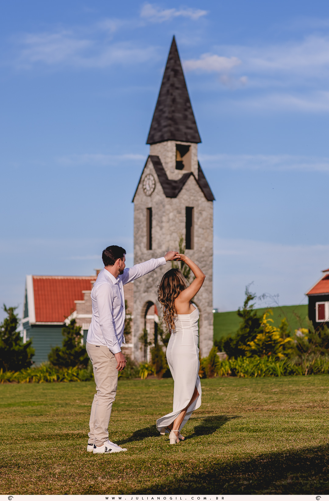 casal dançando em frente a uma torre de estilo holandês