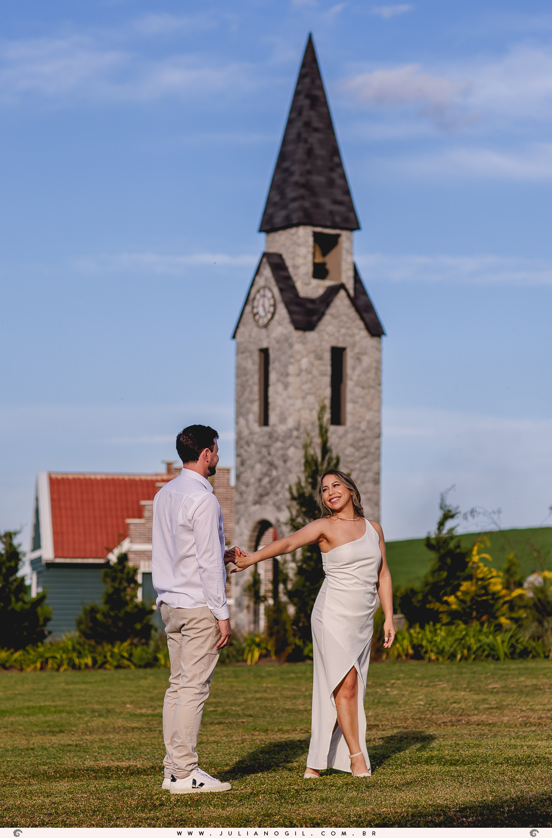 casal dançando em frente a uma torre de estilo holandês