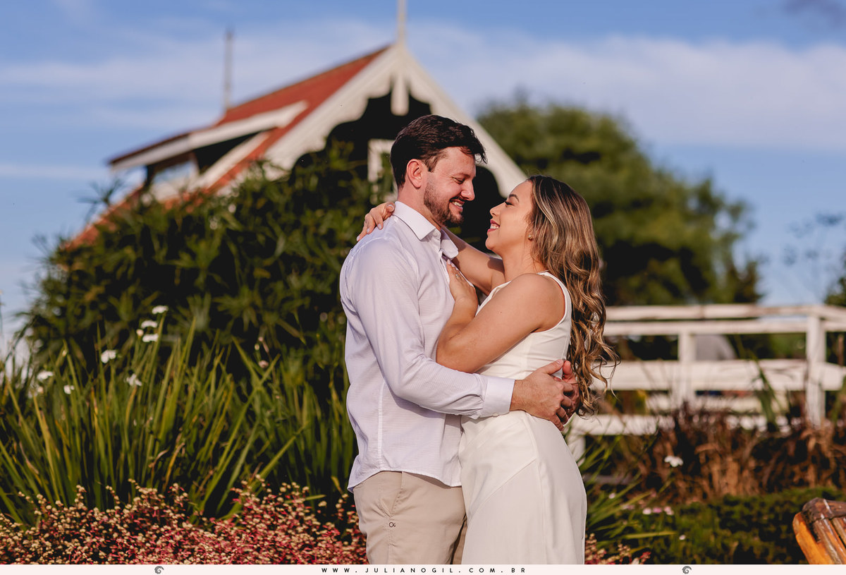 casal abraçado em frente a uma casa de estilo holandês