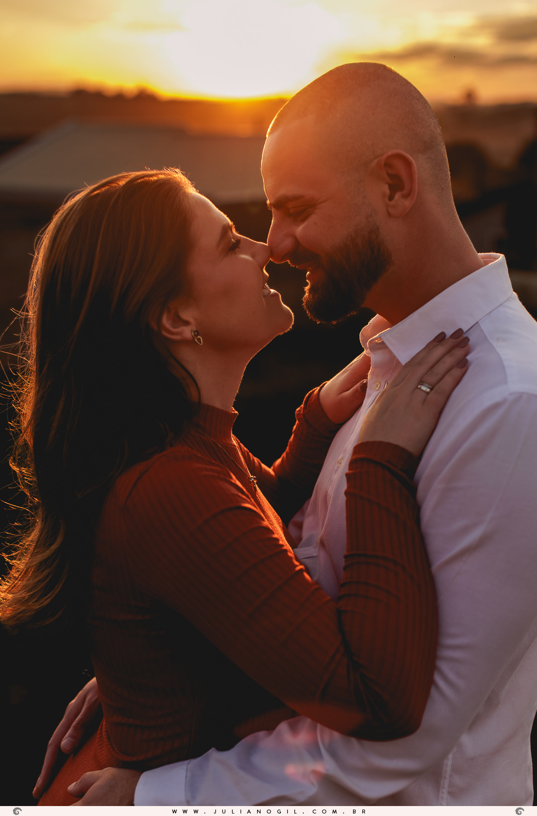 casal de frente um para o outro ao fundo o pôr do sol