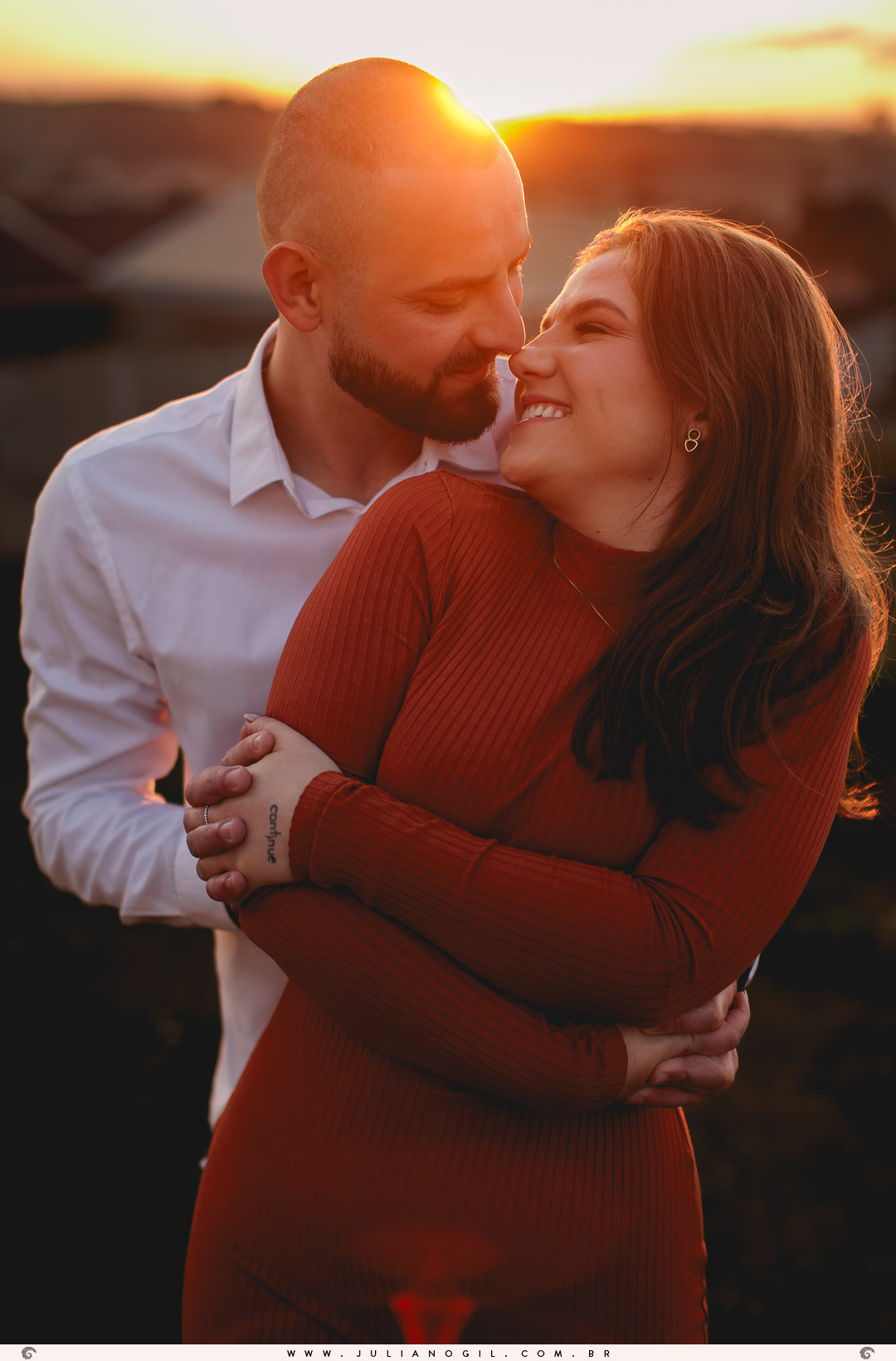 casal de frente um para o outro ao fundo o pôr do sol