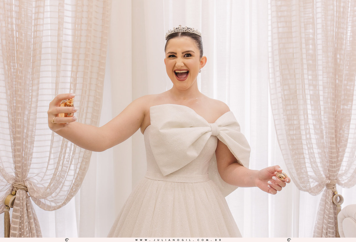 noiva adriele muito sorridente passando perfume durante o making of