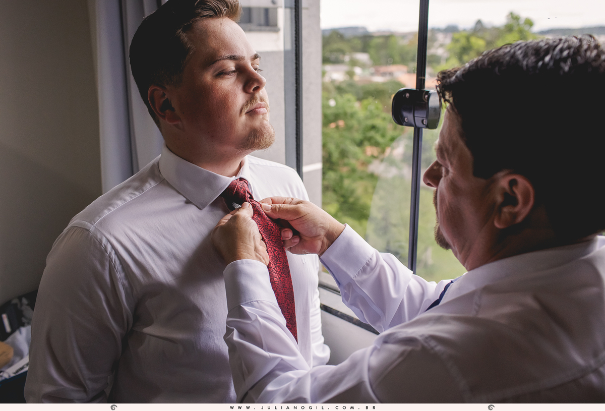 pai do noivo aldo ajustando o nó da gravata no filho durante o making of no hotel mangoni em rebouças no paraná