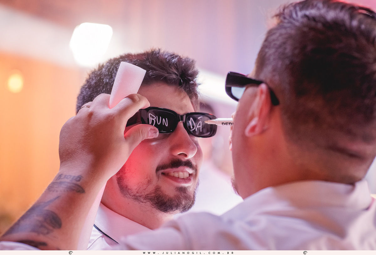 noivo escrevendo nos óculos de festa dos amigos