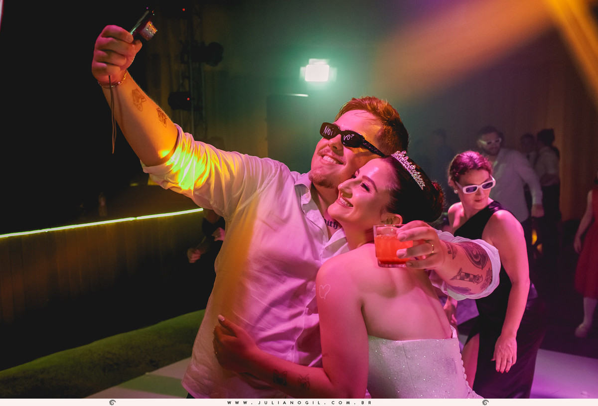 noivos posando para foto com câmera digital antiga