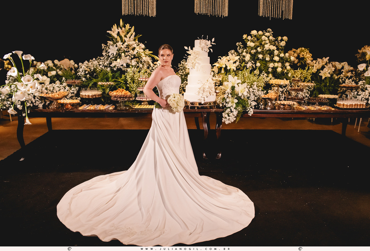 noiva em frente a mesa de doces e bolo