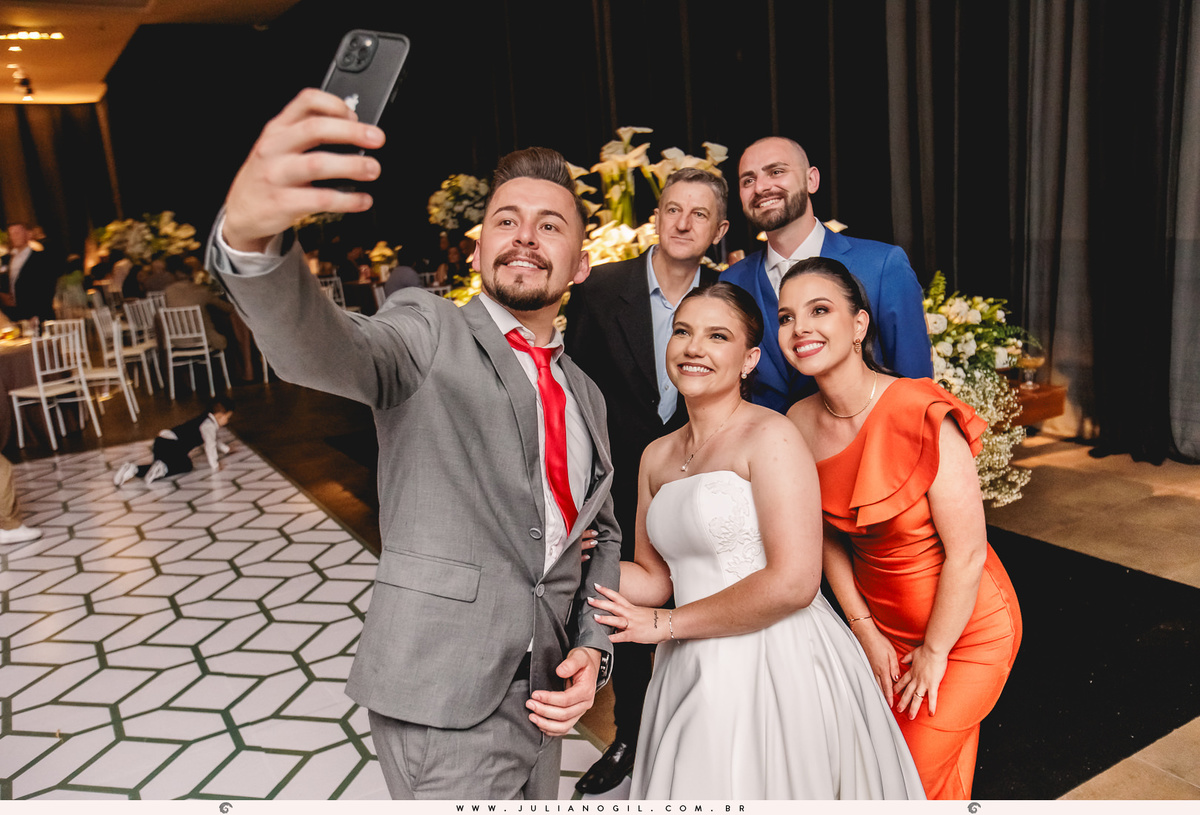 noivos posando para selfie com amigos durante a festa