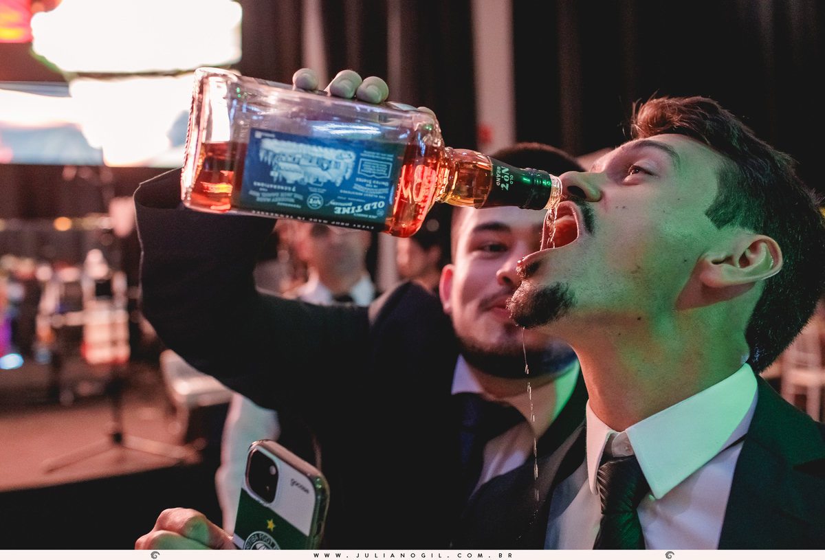 padrinho dando bebida para outro na boca