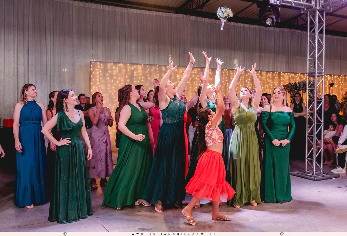 buquê no ar e as convidadas tentando pegá-lo noivos dançando durante a festa de casamento em Rio Azul, Paraná