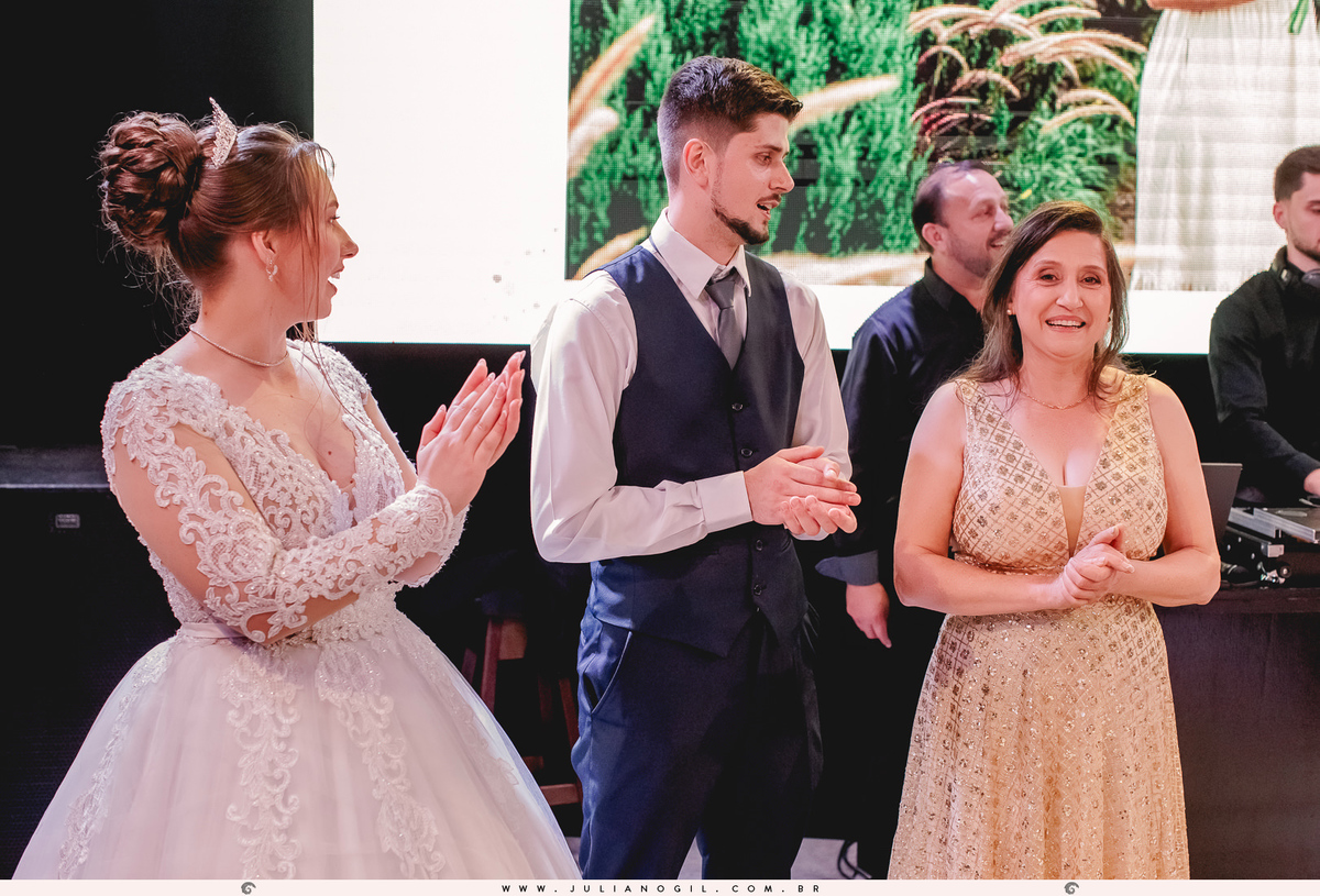 noivos cantando parabéns junto com a mãe do noivo