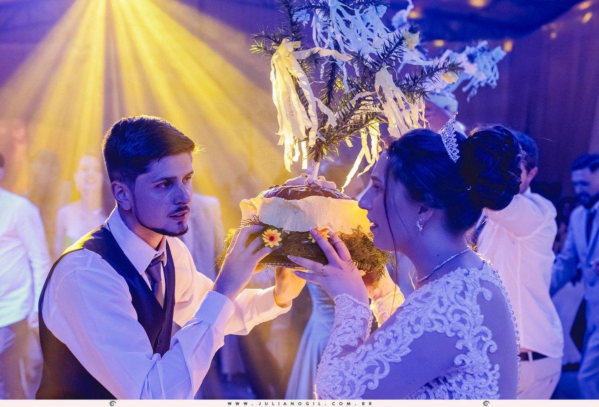 noivos segurando o pão de casamento ucraniano korovai em Rio Azul, Paraná