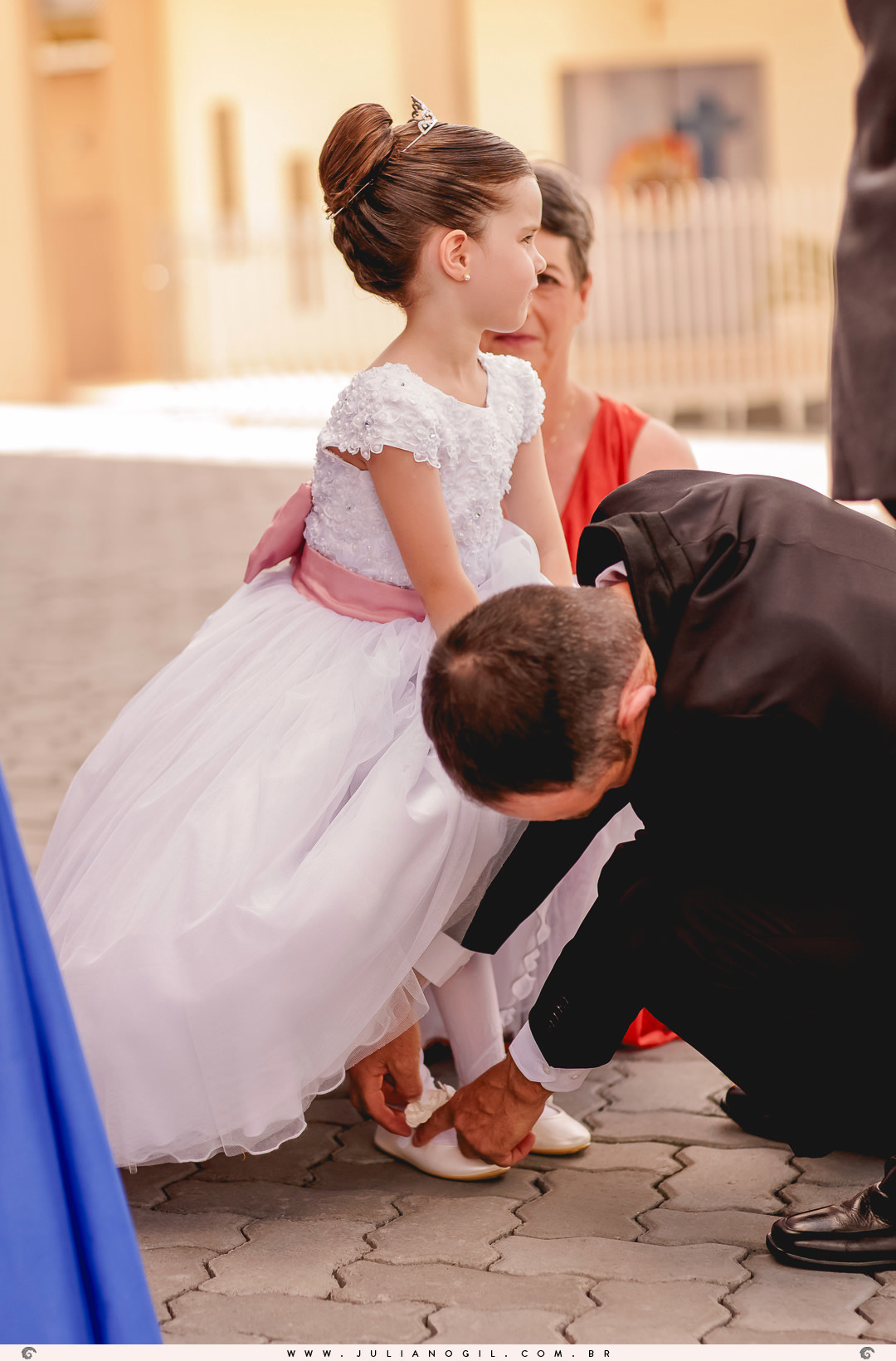 pai da daminha arrumando o sapato dela antes da cerimônia de casamento