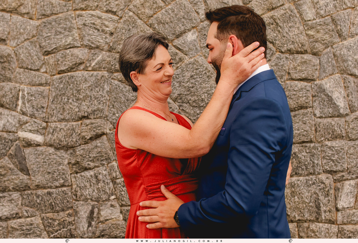 mãe do noivo vestindo o filho antes da cerimônia de casamento