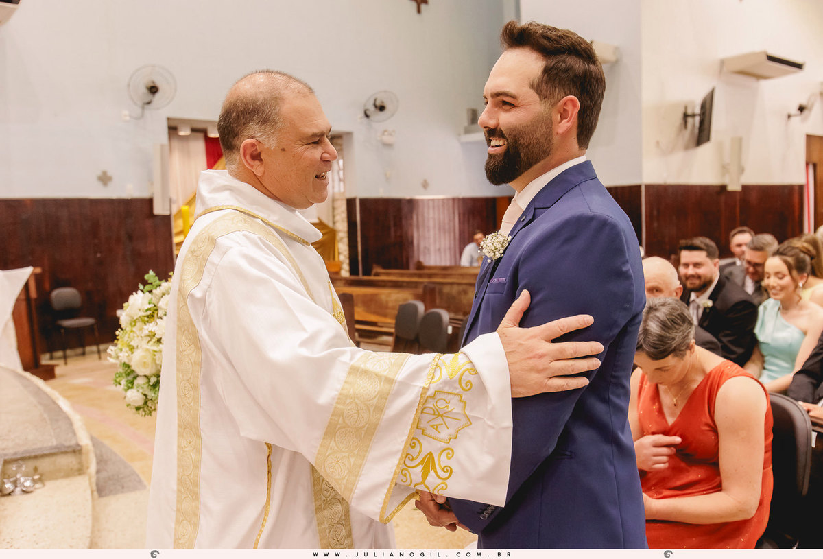 padre cumprimentando o noivo dentro da igreja