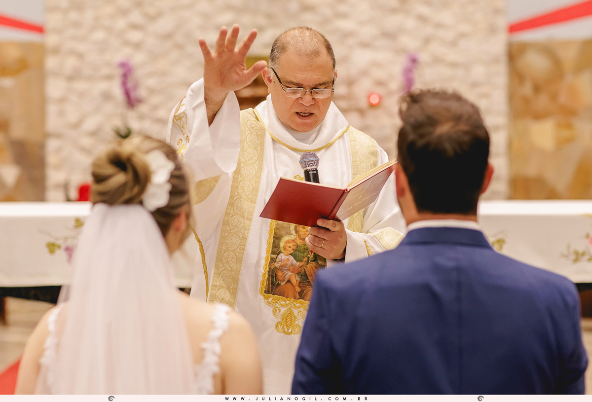 padre abençoando o casal de noivos