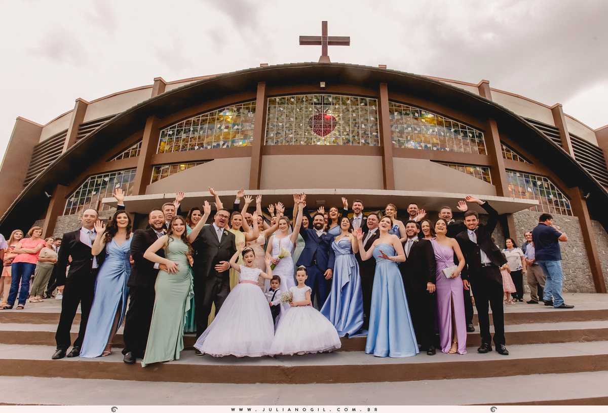 noivos e convidados comemorando em frente a igreja do casamento