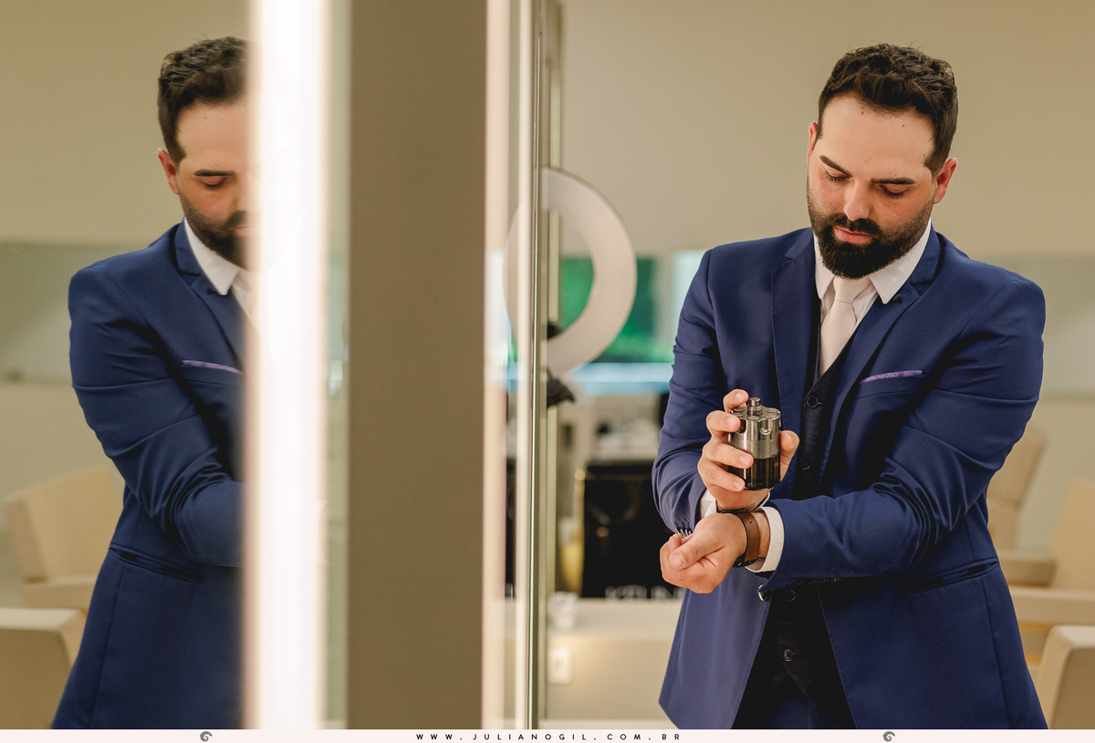 noivo passando o perfume em frente ao espelho