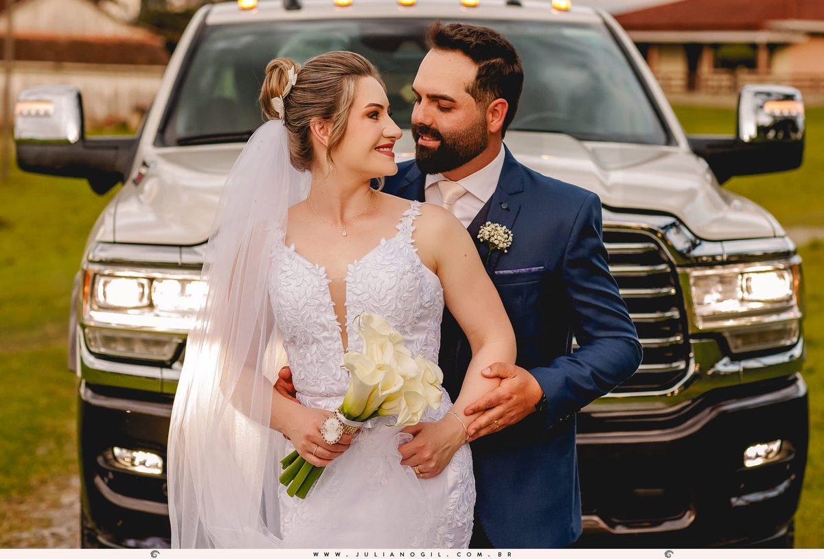 casal posando pós cerimônia em frente a caminhonete ram