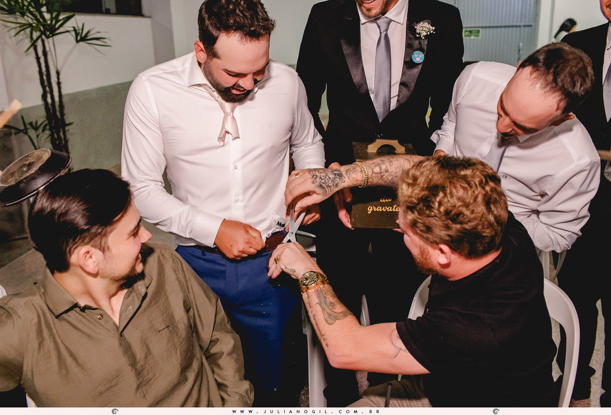 convidado cortando a cueca do noivo durante a festa