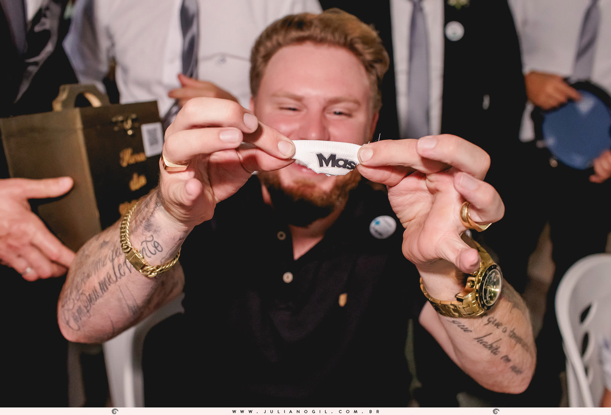 convidado segurando uma fatia da cueca do noivo durante a festa