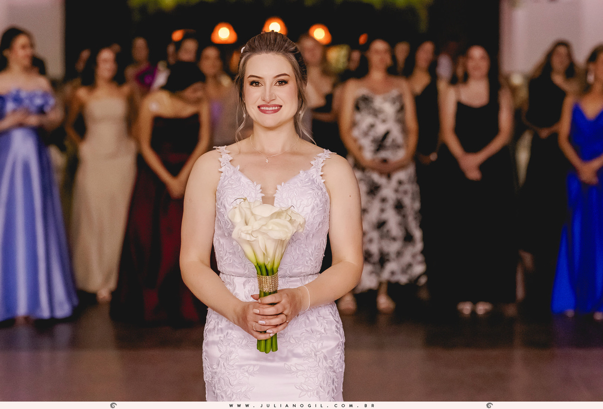 noiva segurando o buquê e convidadas atrás