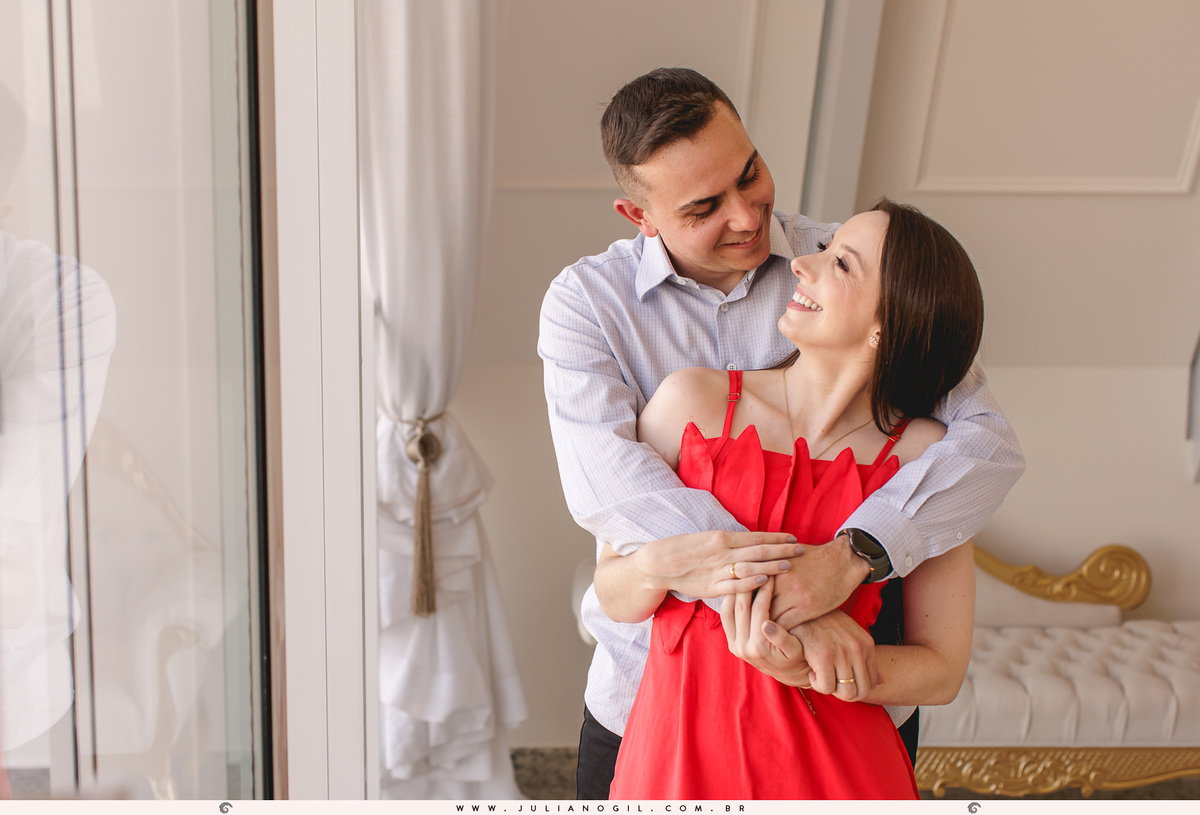 noivos se olhando e abraçados em frente a uma janela