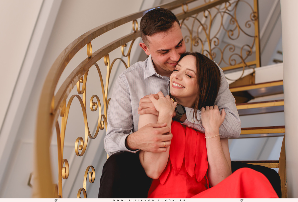 noivos sentados na escada, o noivo está abraçando a noiva