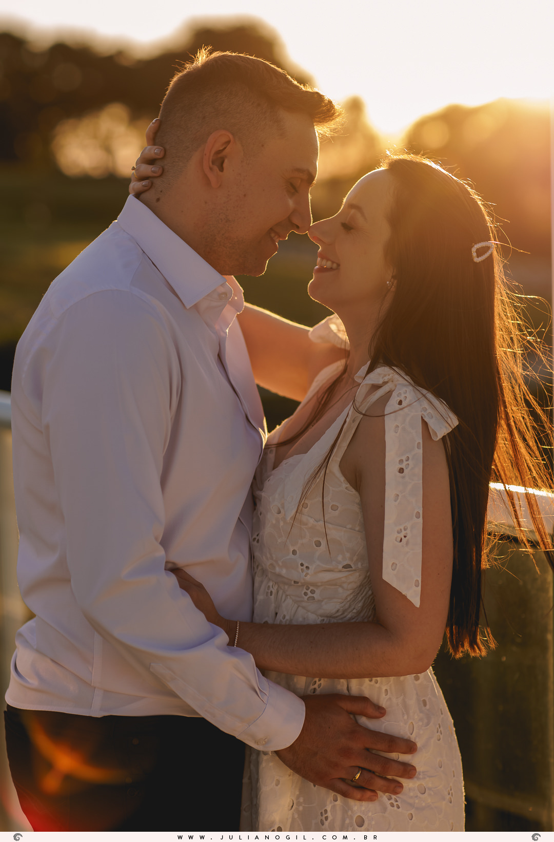casal se olhando com a luz do sol batendo neles ao fundo no pôr do sol