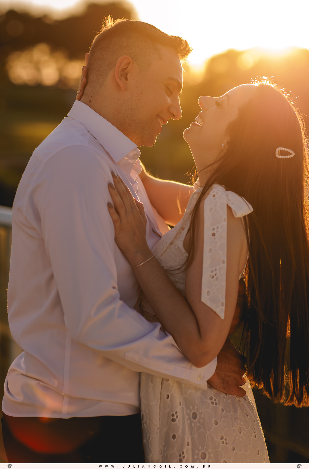 casal se olhando com a luz do sol batendo neles ao fundo no pôr do sol
