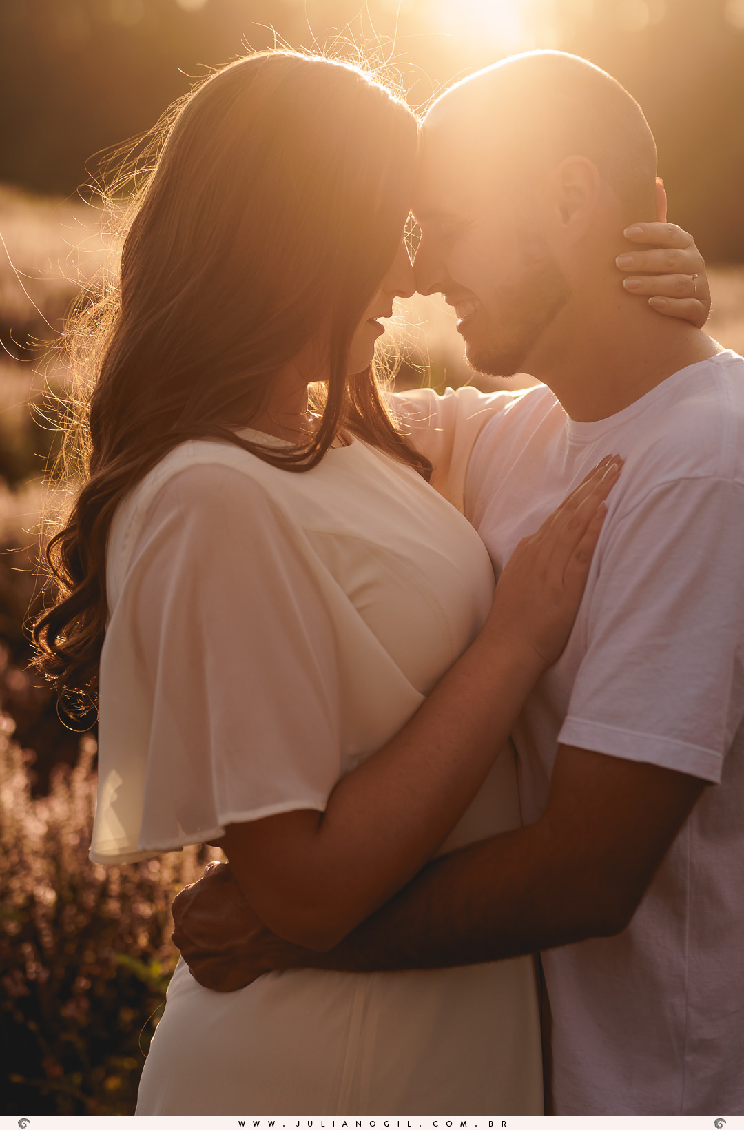 casal abraçados com o pôr do sol ao fundo no ensaio de pré casamento