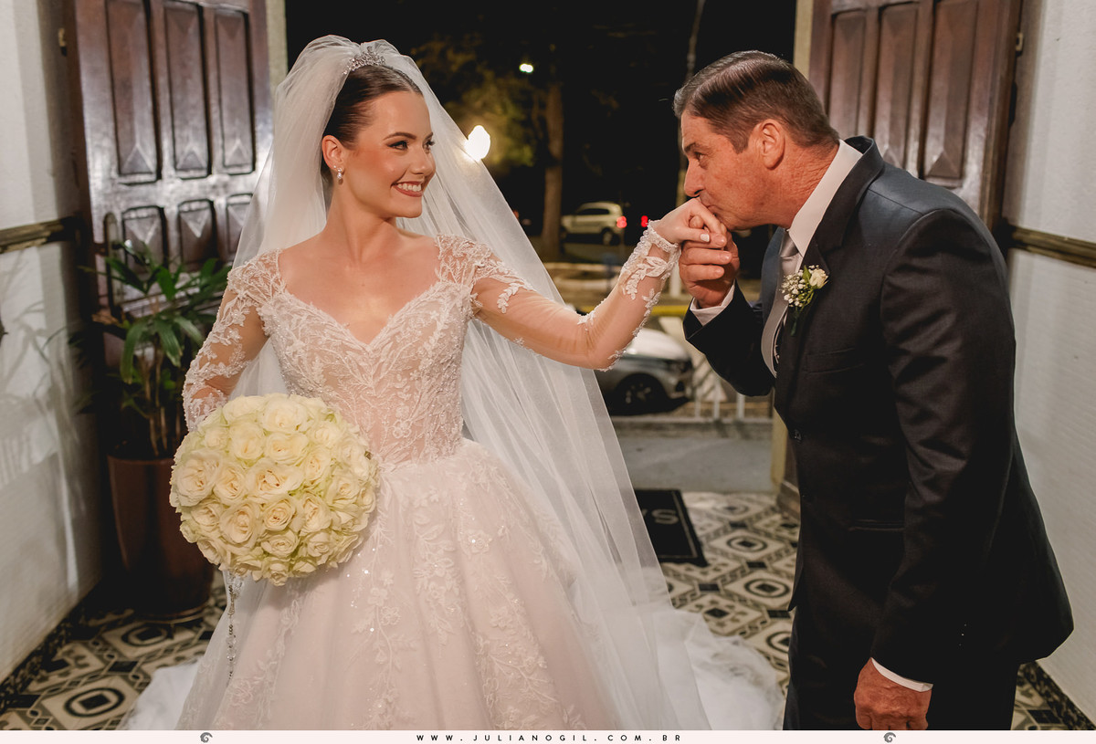 pai da noiva beijando a mão da filha antes da entrada na igreja