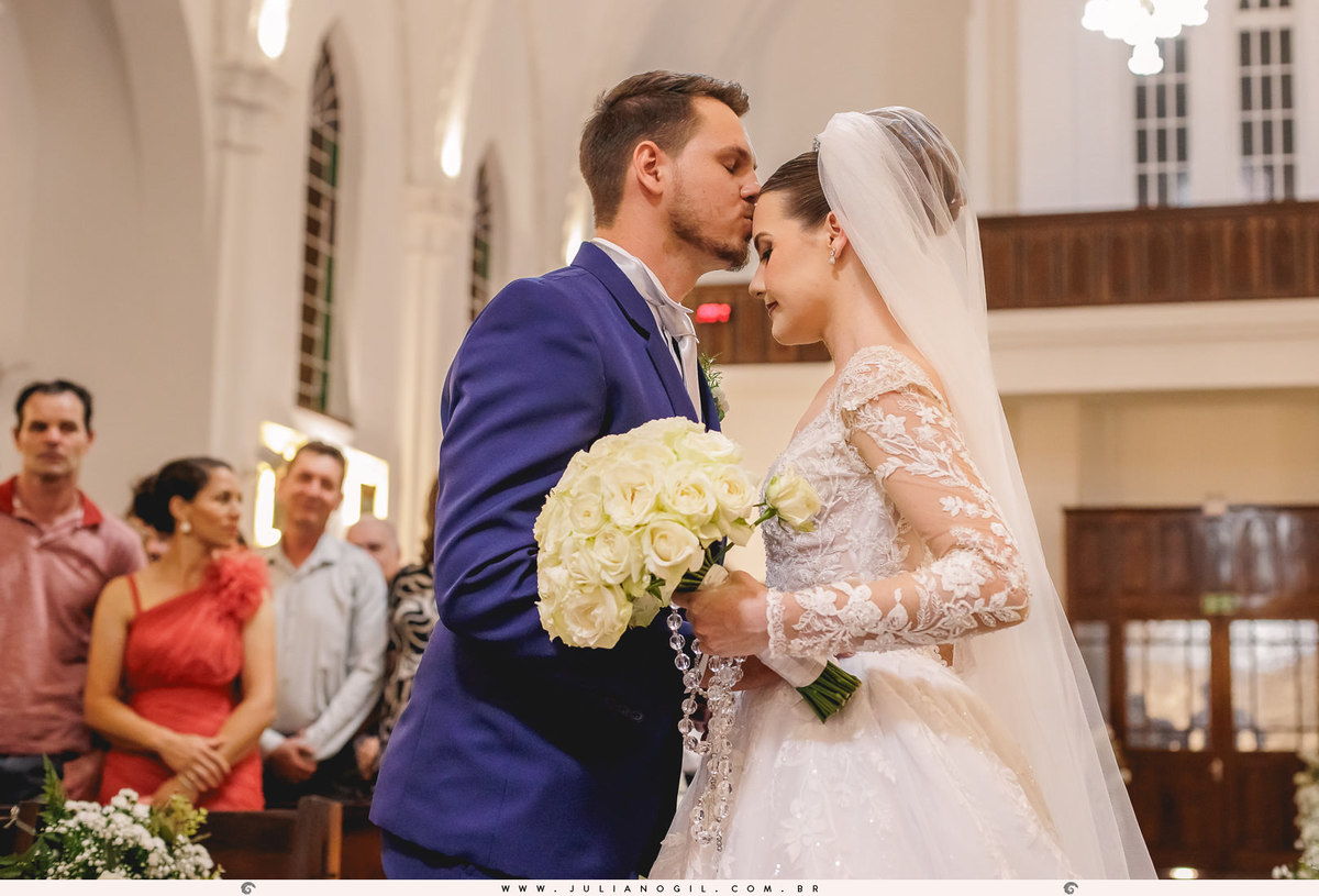 noivo recebendo a noiva com um beijo na testa