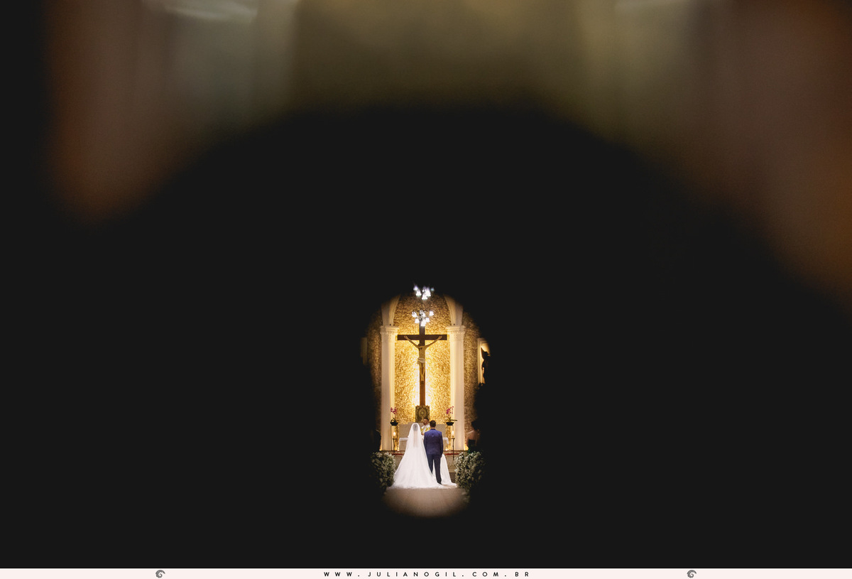 noivos no altar sendo vistos através da fechadura da porta da igreja