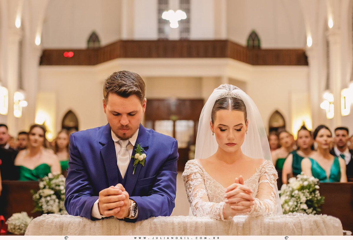 noivos rezando ajoelhados em frente ao altar