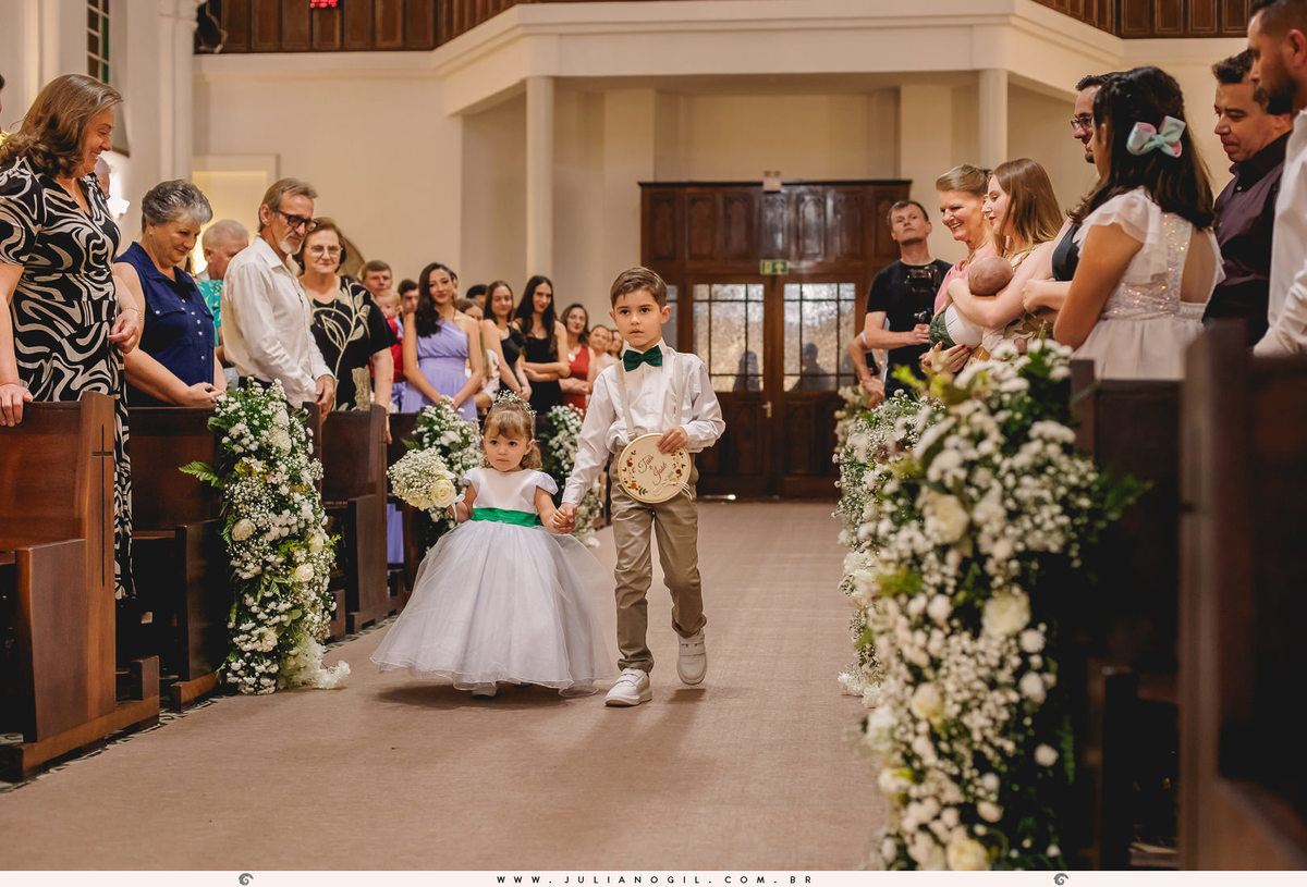 noivinha e pagem entrando na igreja com as alianças