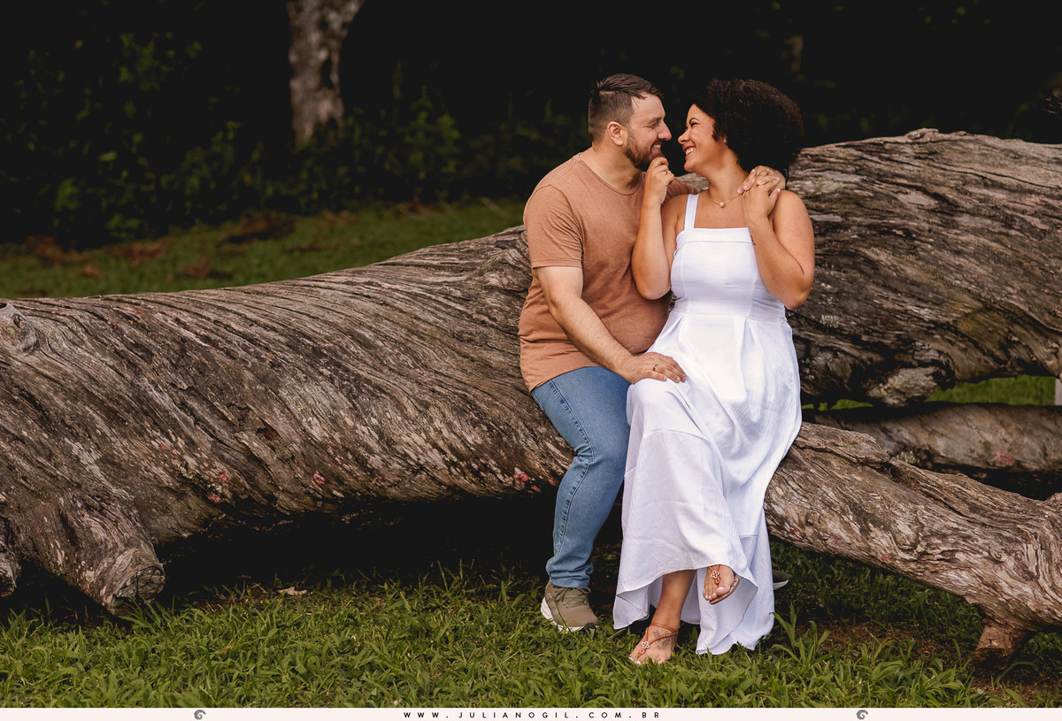 casal sentados se abraçando em cima de uma araucária caída na floresta nacional de irati