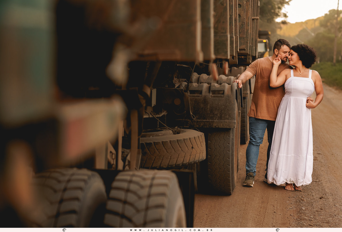 noivos encostados em um caminhão carregado de toras