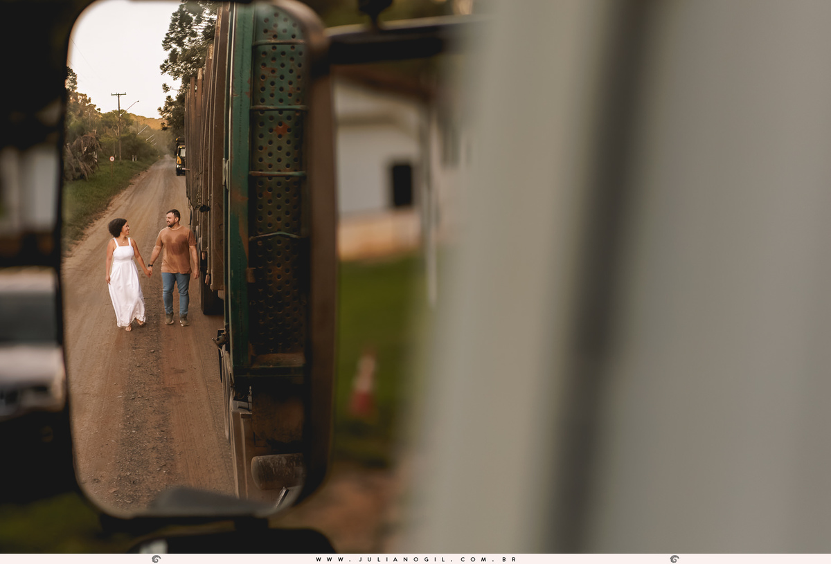 casal sendo visto pelo espelho do caminhão carregado de toras  na floresta nacional de irati