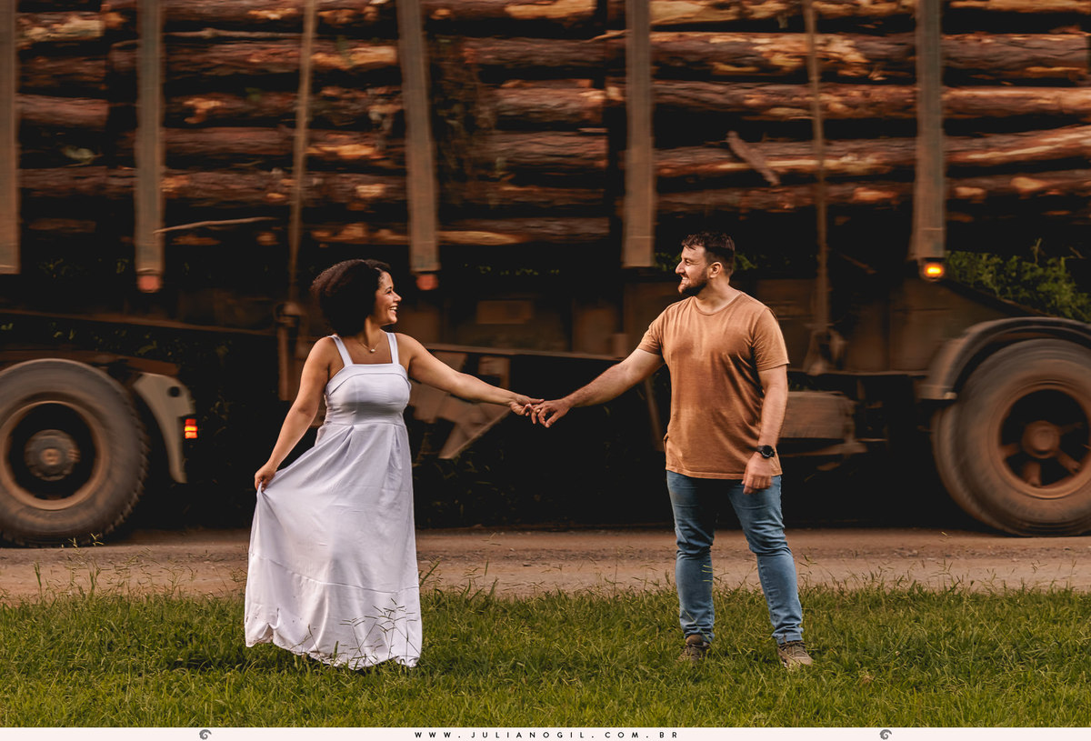casal em frente a uma carreta carregada de toras   na floresta nacional de irati