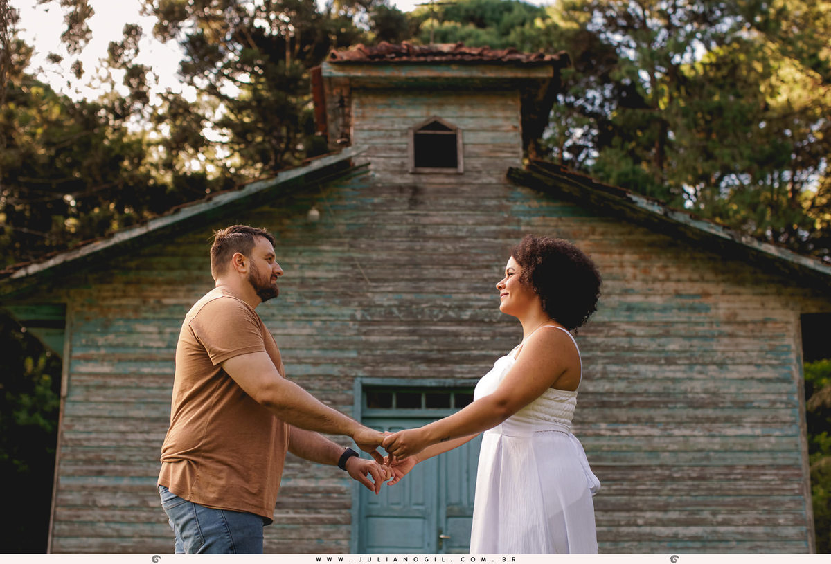 casal se olhando de mãos dadas em frente a uma igreja antiga
