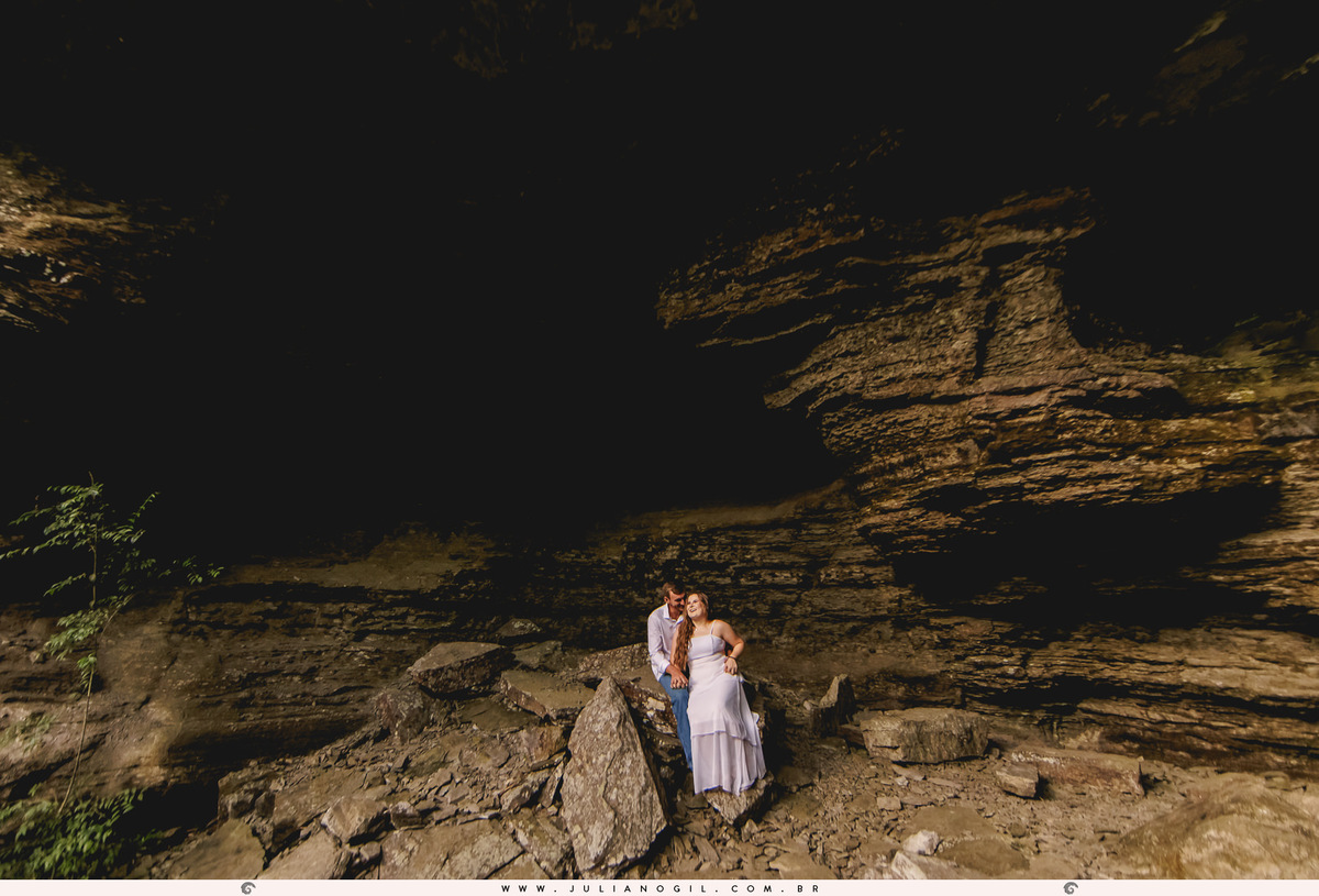 casal sentados sob as pedras de uma gruta