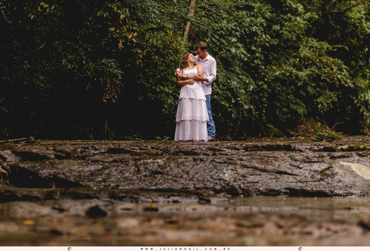 casal abraçados sob as pedras de um riacho