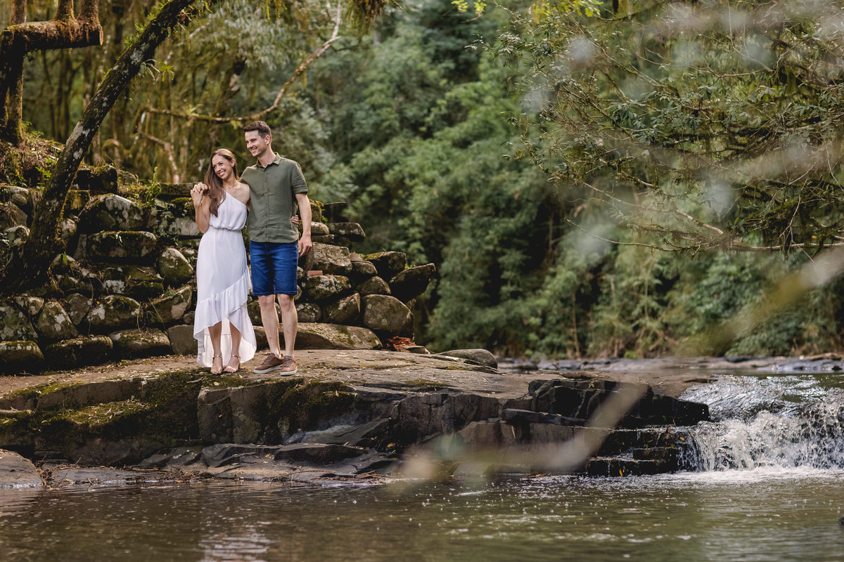 casal andando sobre as pedras do rio
