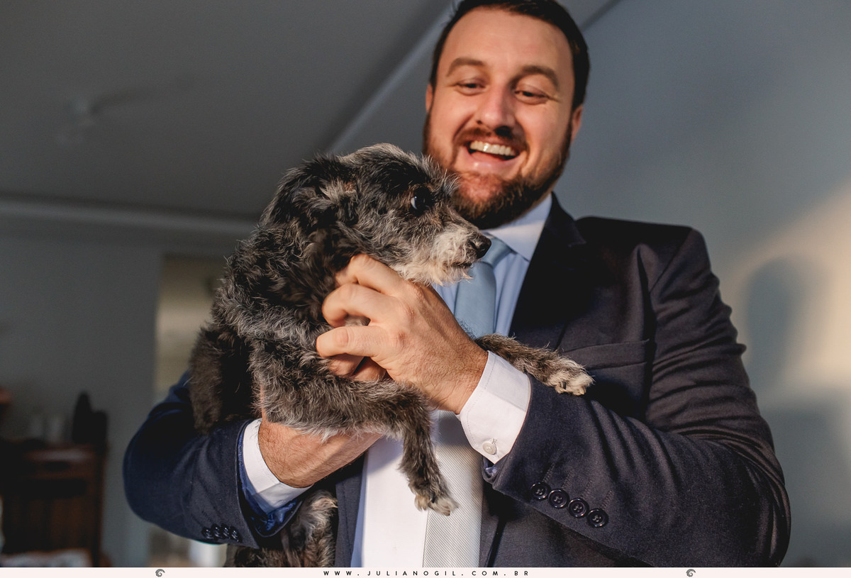 noivo segurando o cachorro de estimação da família