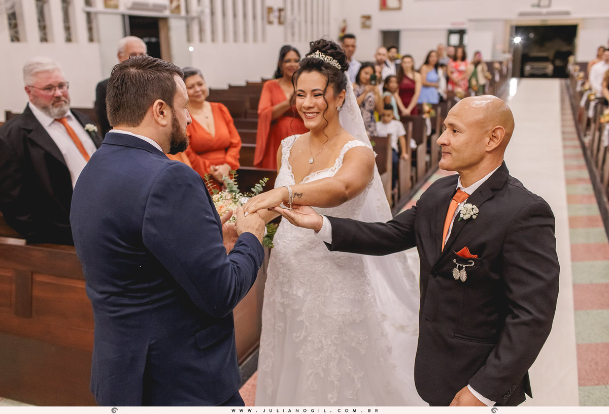 irmão da noiva entregando a mão da noiva para o noivo no altar da igreja perpétuo socorro